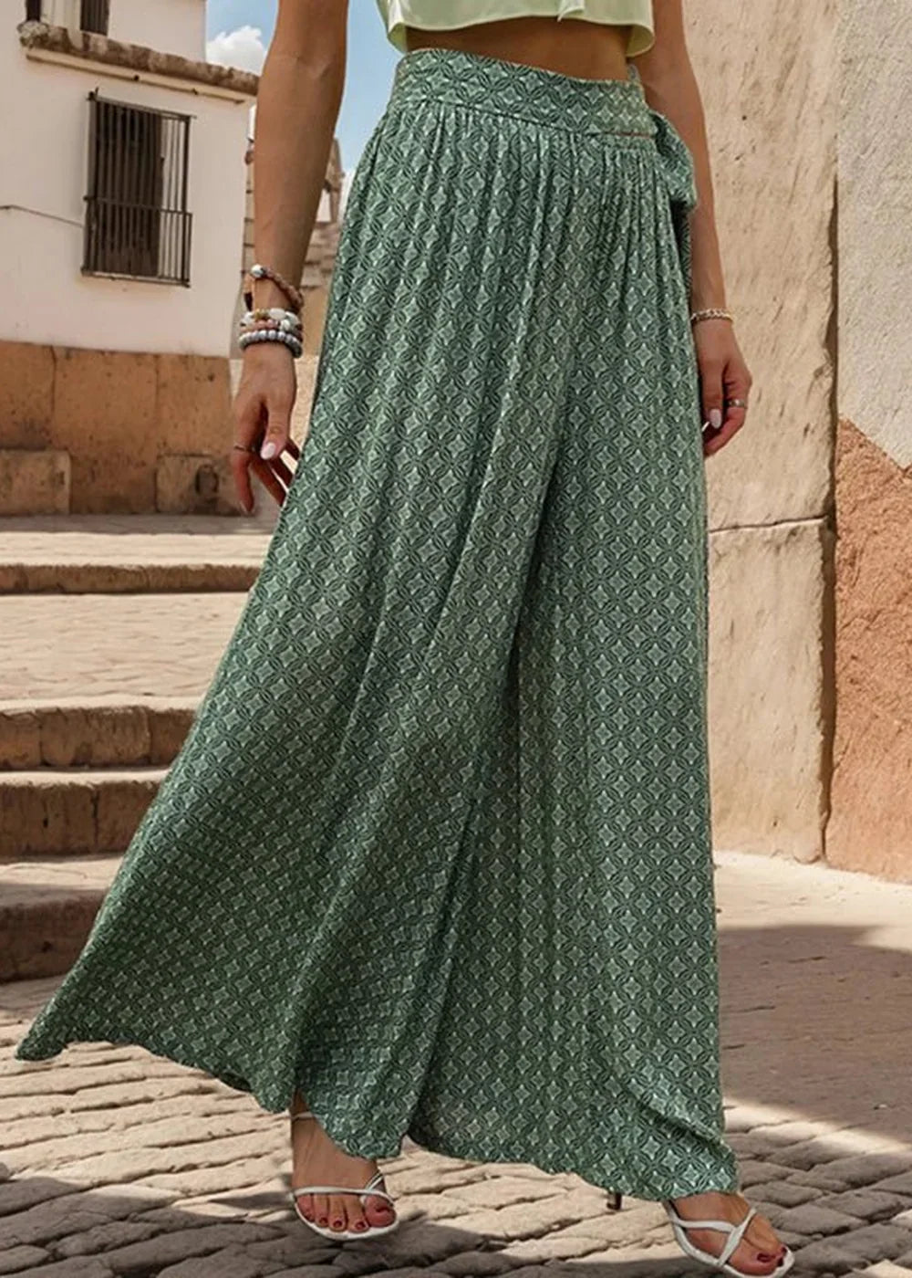Green wide-leg palazzo pants with a geometric pattern and tie-waist detail.
