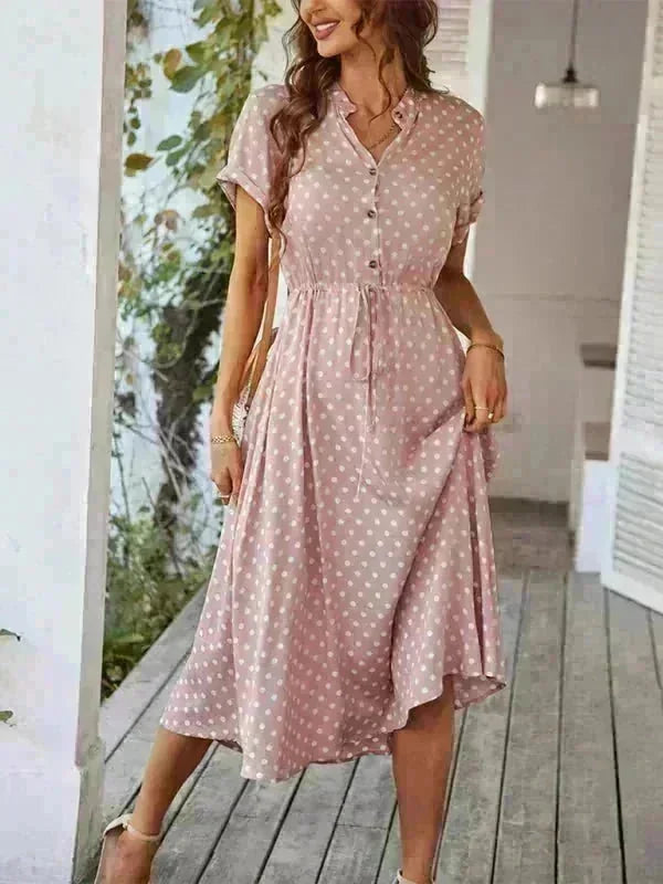 Pink polka dot rayon dress with a cinched waist and button-up front, shown on a model.