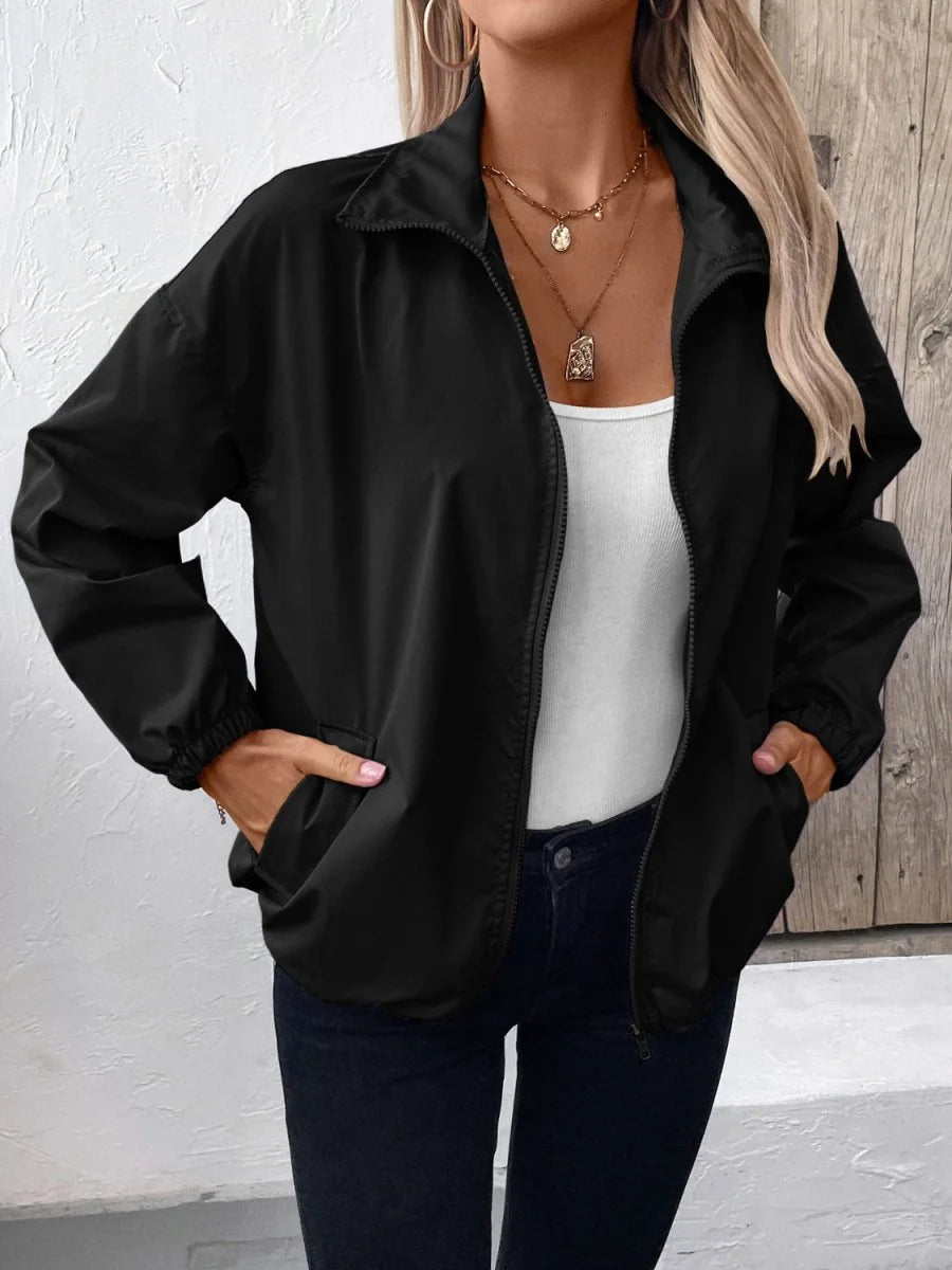 Black polyester jacket with zipper closure and side pockets, worn by a model.