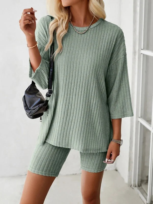 Sage green ribbed knit short suit with a relaxed fit top and biker shorts, worn by a model.
