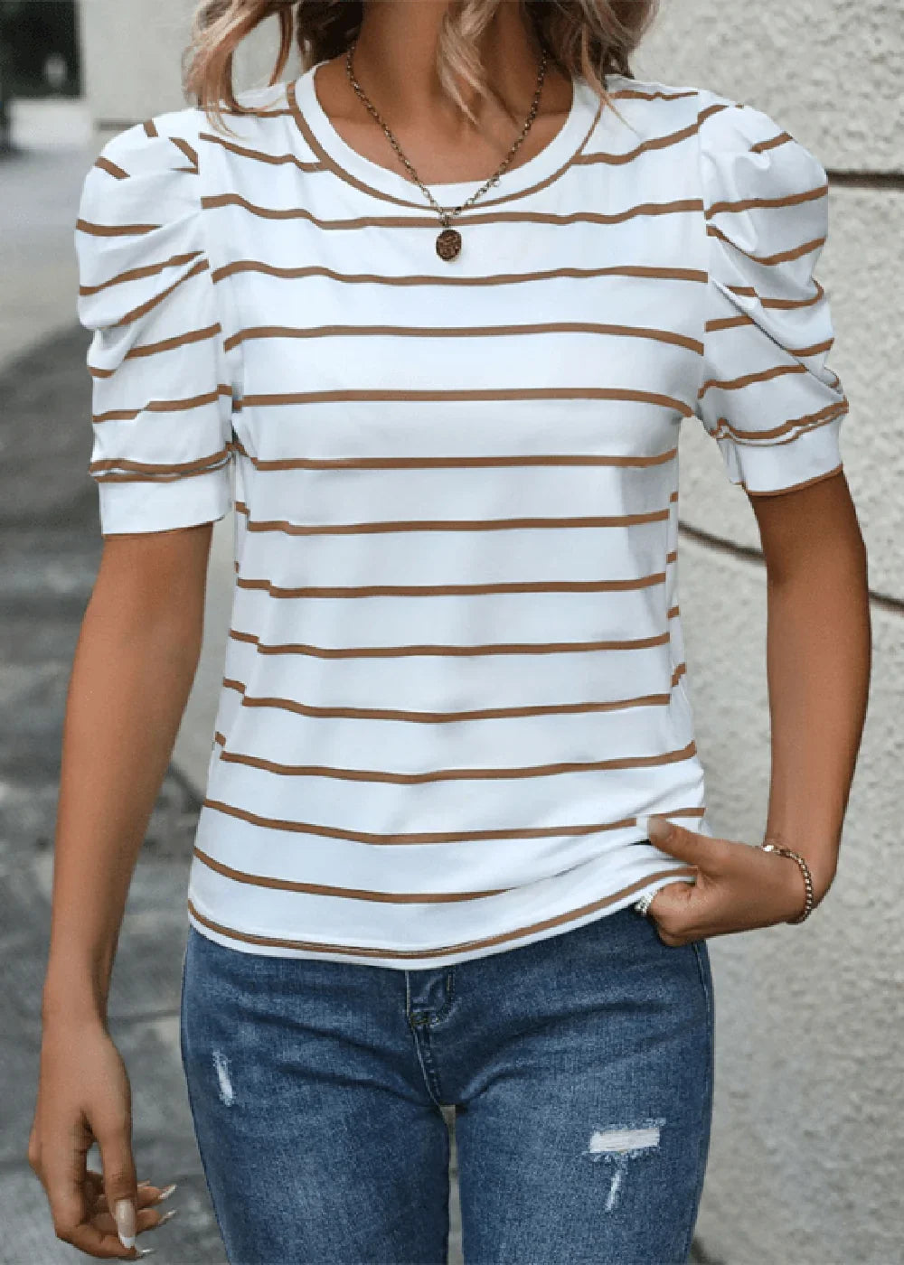 White t-shirt with brown stripes, puff sleeves, and a crew neck, worn by a model in blue jeans.