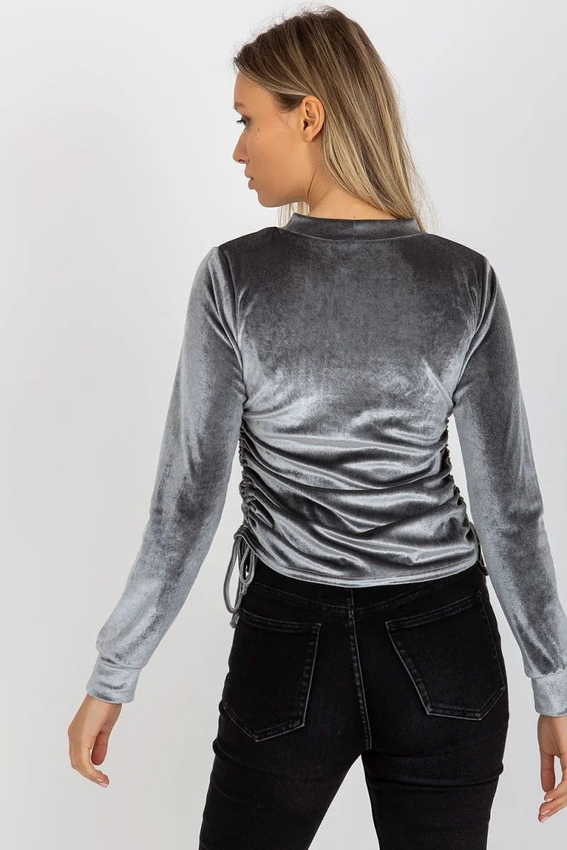 Gray velvet long-sleeve top with ruched sides and drawstring detail on model.