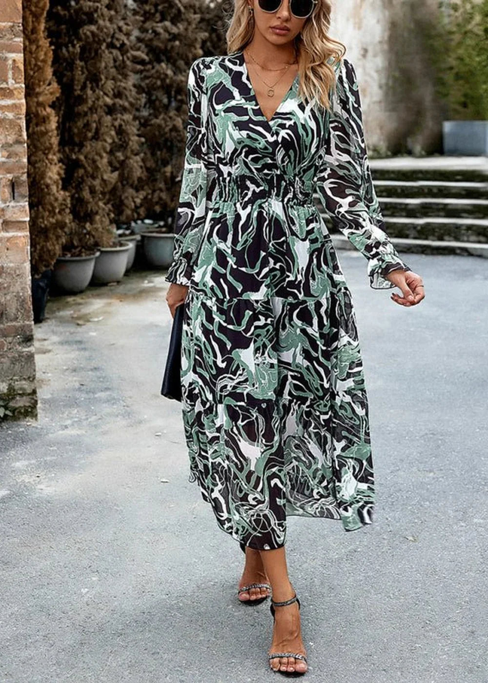 Green and black abstract print maxi dress with V-neck and long sleeves, on model.