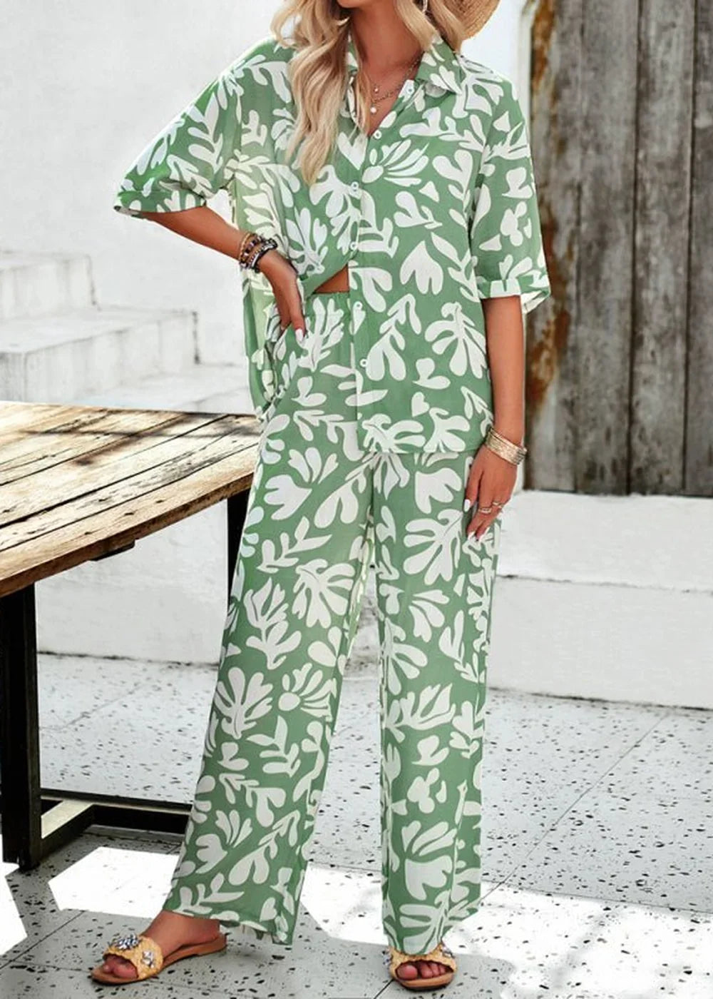 Green and white leaf print wide-leg pant suit with a collared shirt on a model.
