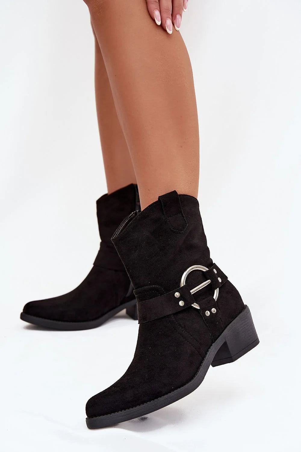 Black suede cowboy boots with a silver ring detail and a block heel, shown on a model.
