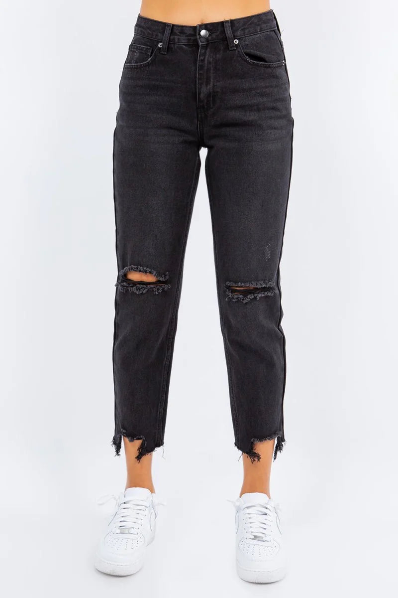 Black high-waisted distressed denim jeans with frayed hems and knee rips, on model.