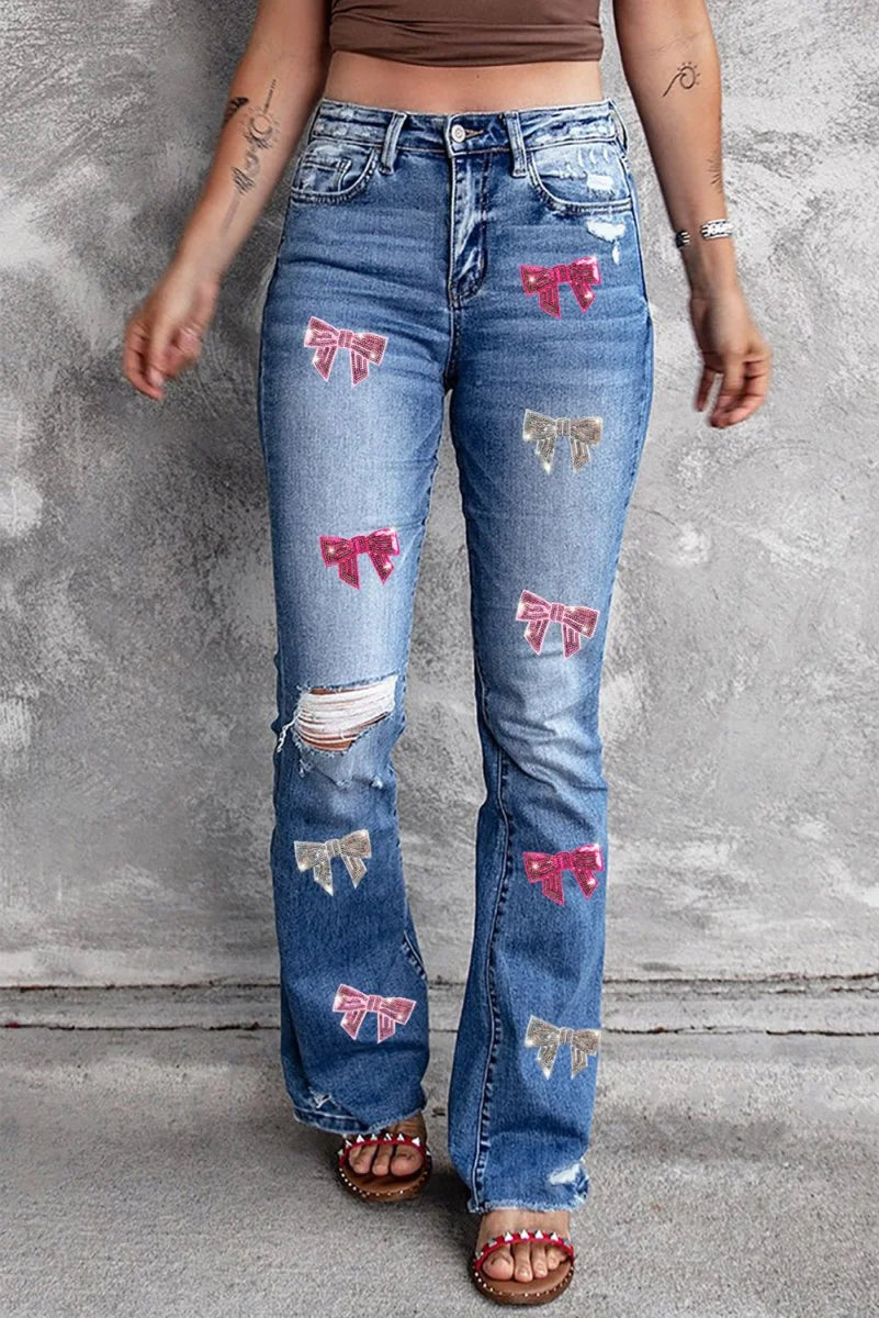 Medium wash distressed bootcut jeans with sequin bow