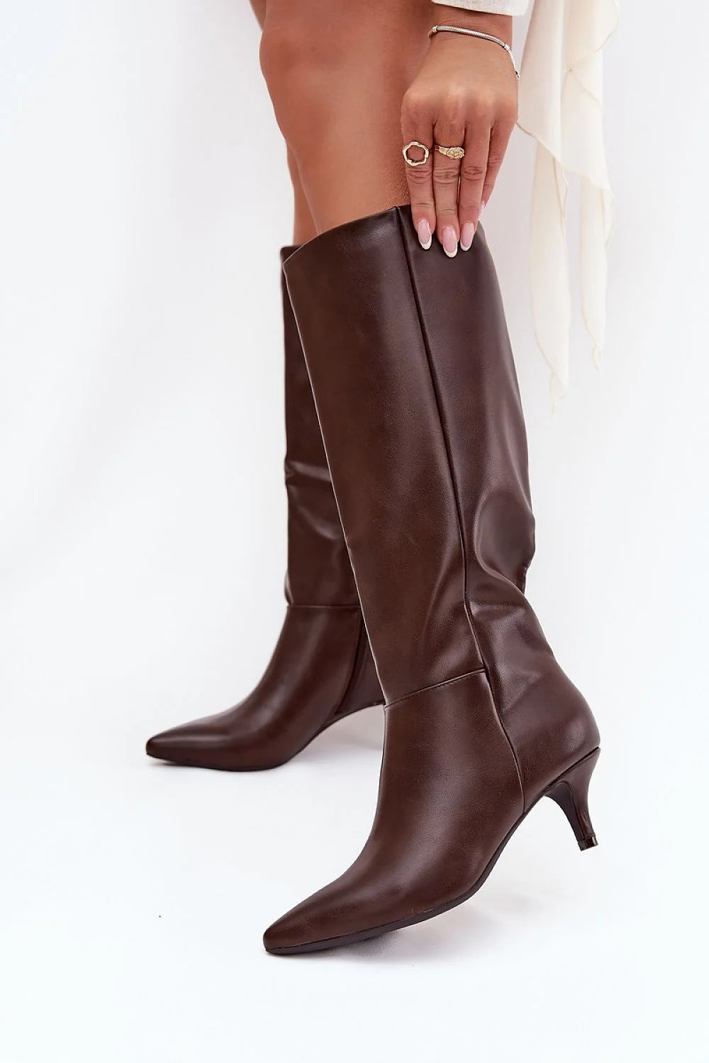 Brown leather knee-high boots with pointed toe and kitten heel.