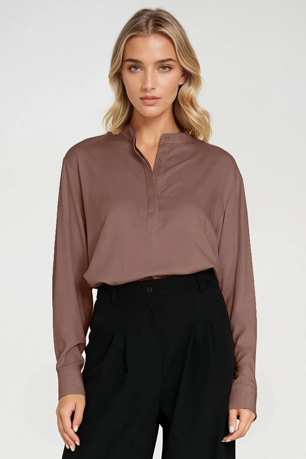 Brown long-sleeved collared shirt with button detail, paired with black pleated pants, worn by a model.