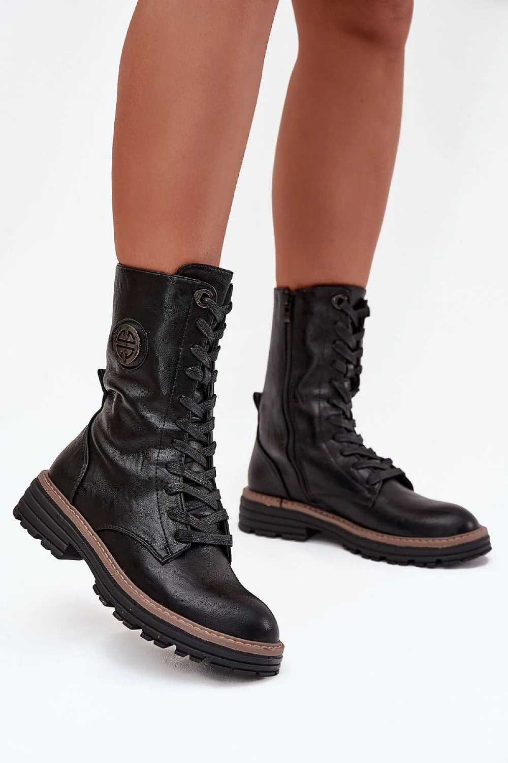 Black leather lace-up combat boots with lug soles and a circular emblem on the side.