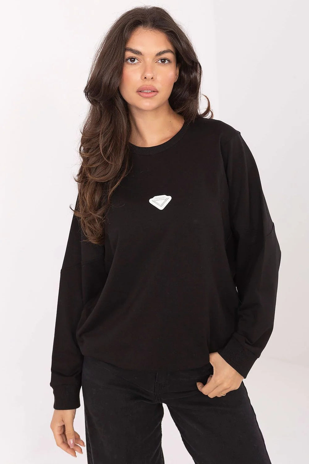 Black crewneck sweatshirt with a small white diamond logo on the chest, worn by a woman with dark hair.