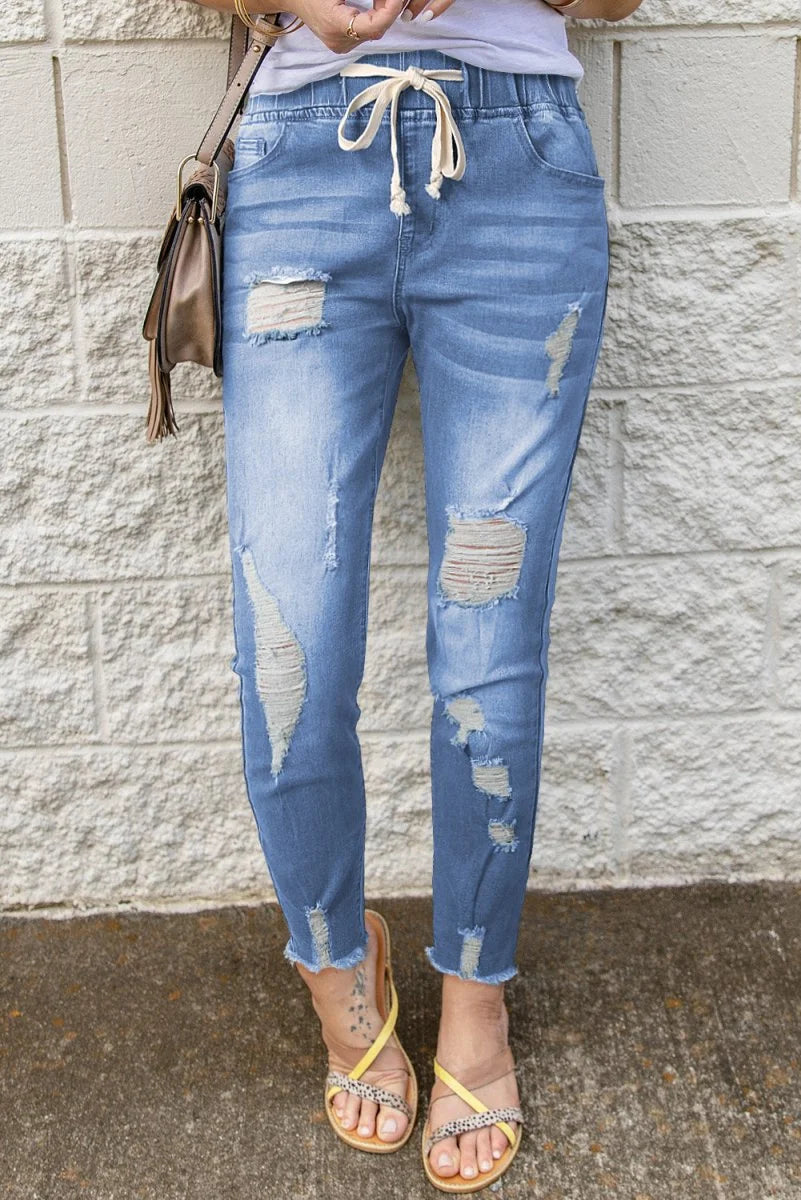 Light wash distressed drawstring jeans with raw hem