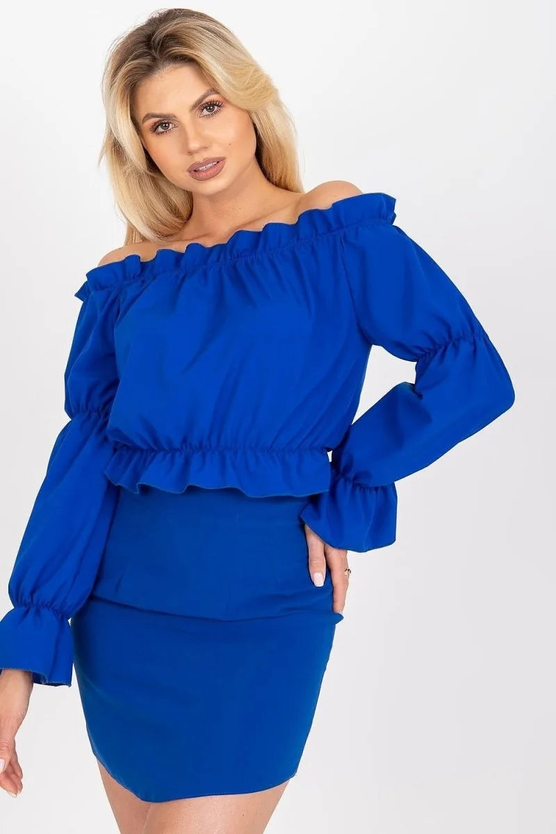 Woman in a royal blue off-the-shoulder top with ruffled neckline and cuffs, paired with a matching mini skirt.