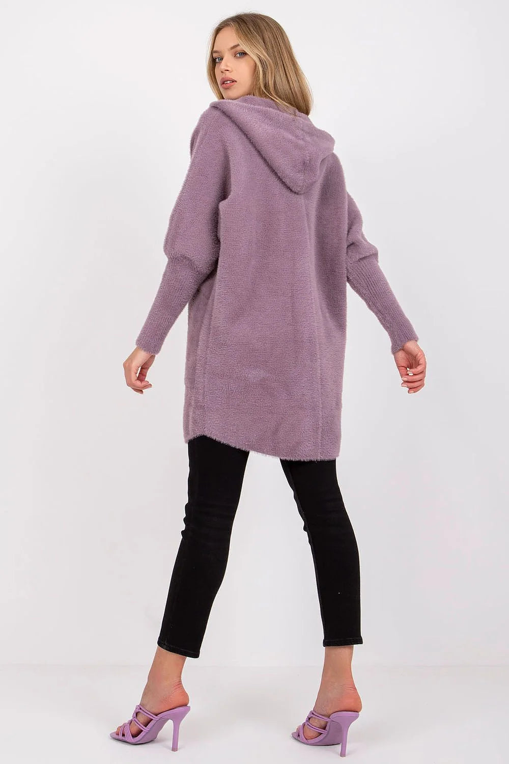 Fluffy lavender hooded cardigan with voluminous sleeves and black skinny jeans.