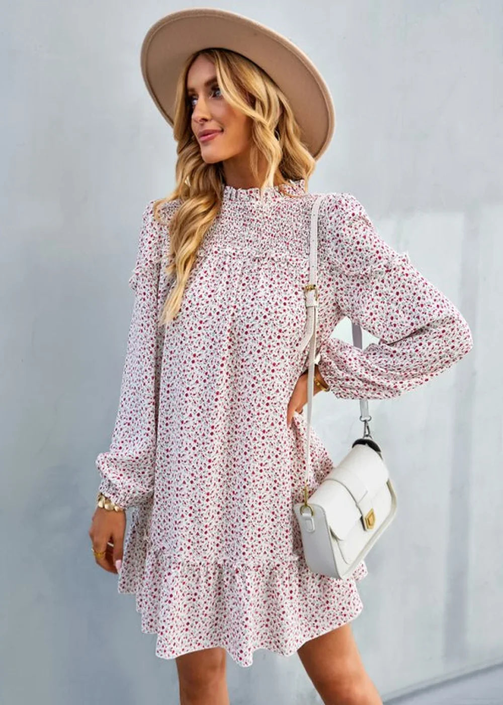 White floral print dress with smocked neckline, ruffled hem, and white crossbody bag on model.