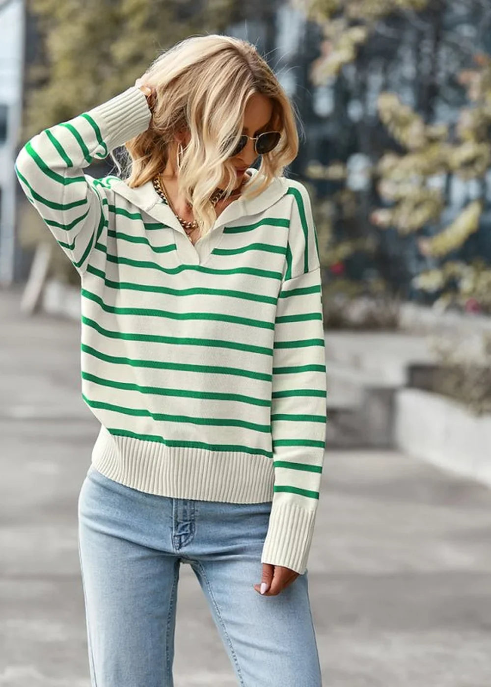 Cream and green striped relaxed fit sweater with a collar and dropped shoulders on a model.
