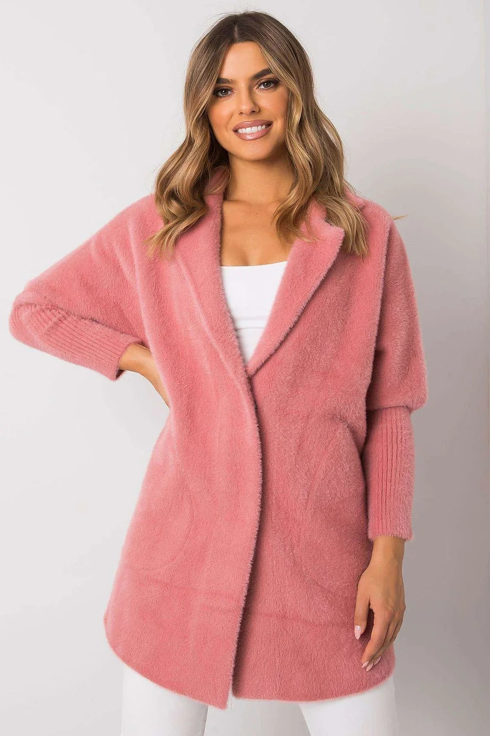 Soft pink fluffy angora blend cardigan with ribbed cuffs and collar on a smiling model.