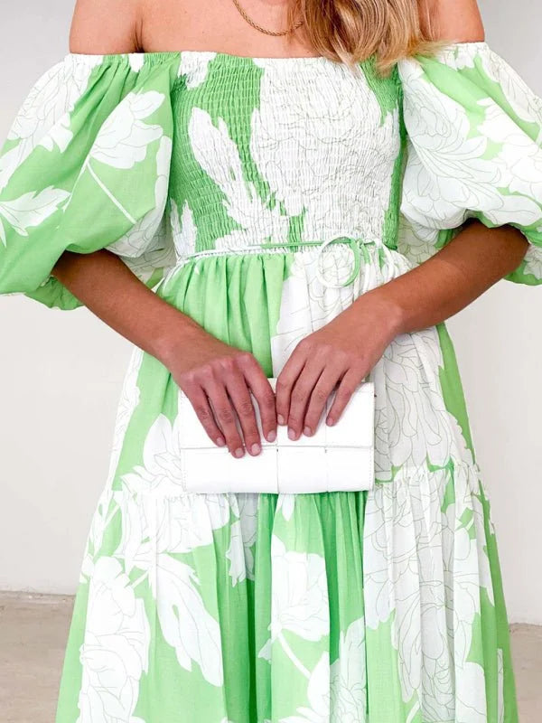 Off-the-shoulder lime green dress with white floral print, smocked bodice, and balloon sleeves.