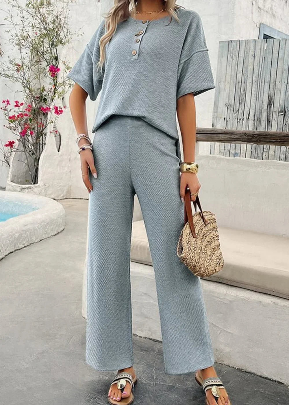 Light blue ribbed knit pant suit with wide leg pants and short sleeve top, on model.