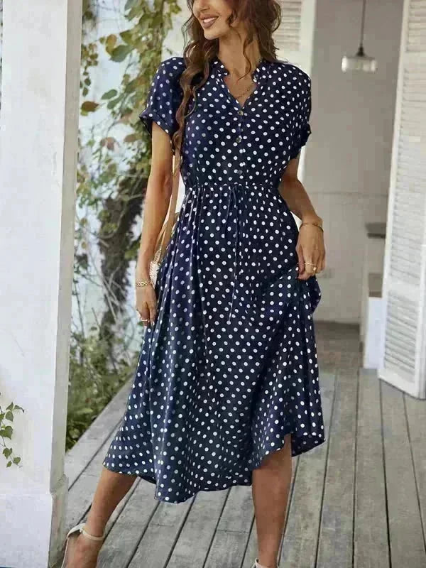 Navy blue rayon dress with a white polka dot pattern, cinched waist, and midi length, worn by a model.