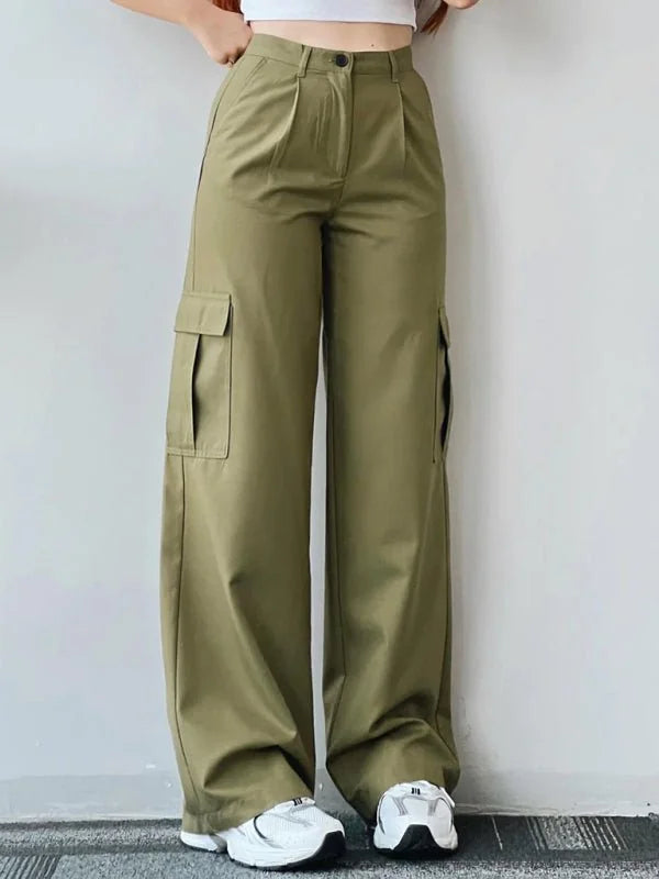 Olive green relaxed fit cargo pants with pleats and large side pockets, worn with white sneakers.