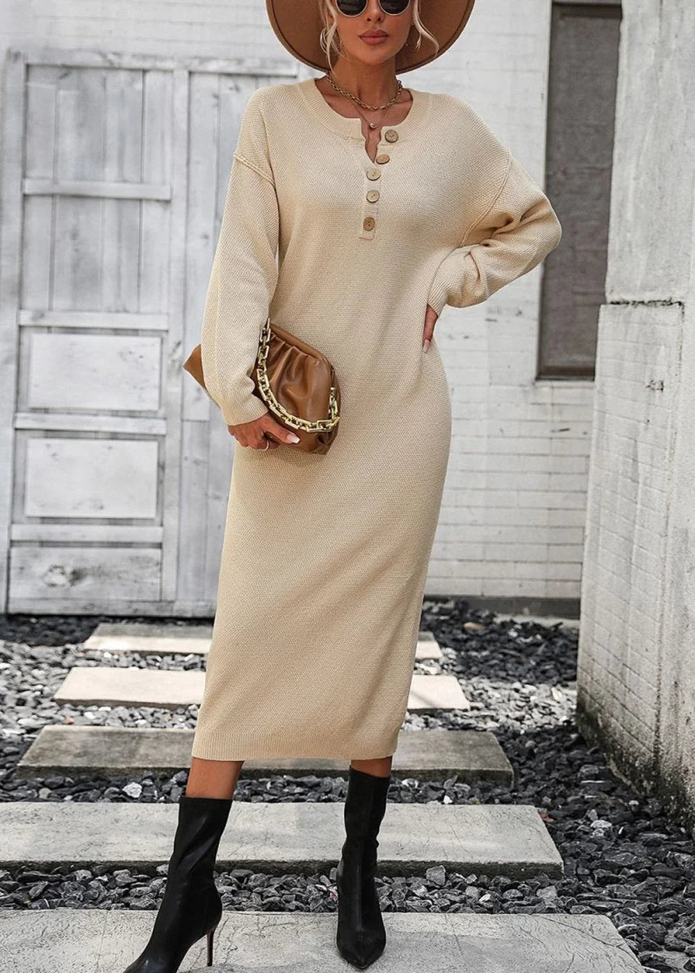 Beige knit sweater dress with button details, worn by a model with a brown hat and black boots.