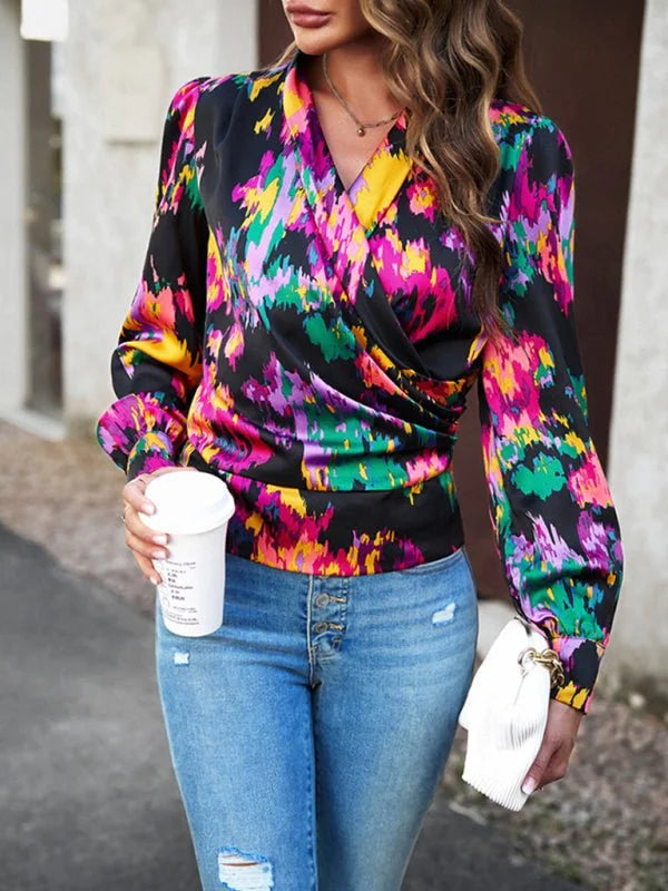 Vibrant abstract print wrap blouse with long sleeves, paired with distressed denim jeans.