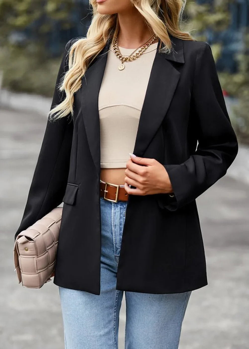Black blazer with lapel collar over a beige crop top, light blue jeans, and brown belt.