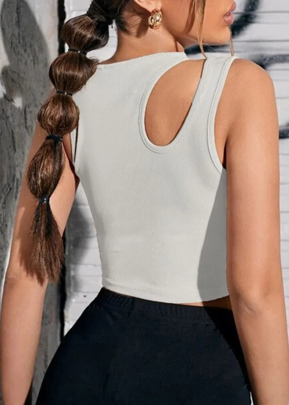 White ribbed knit cropped tank top with a cutout detail on the shoulder, worn by a model.