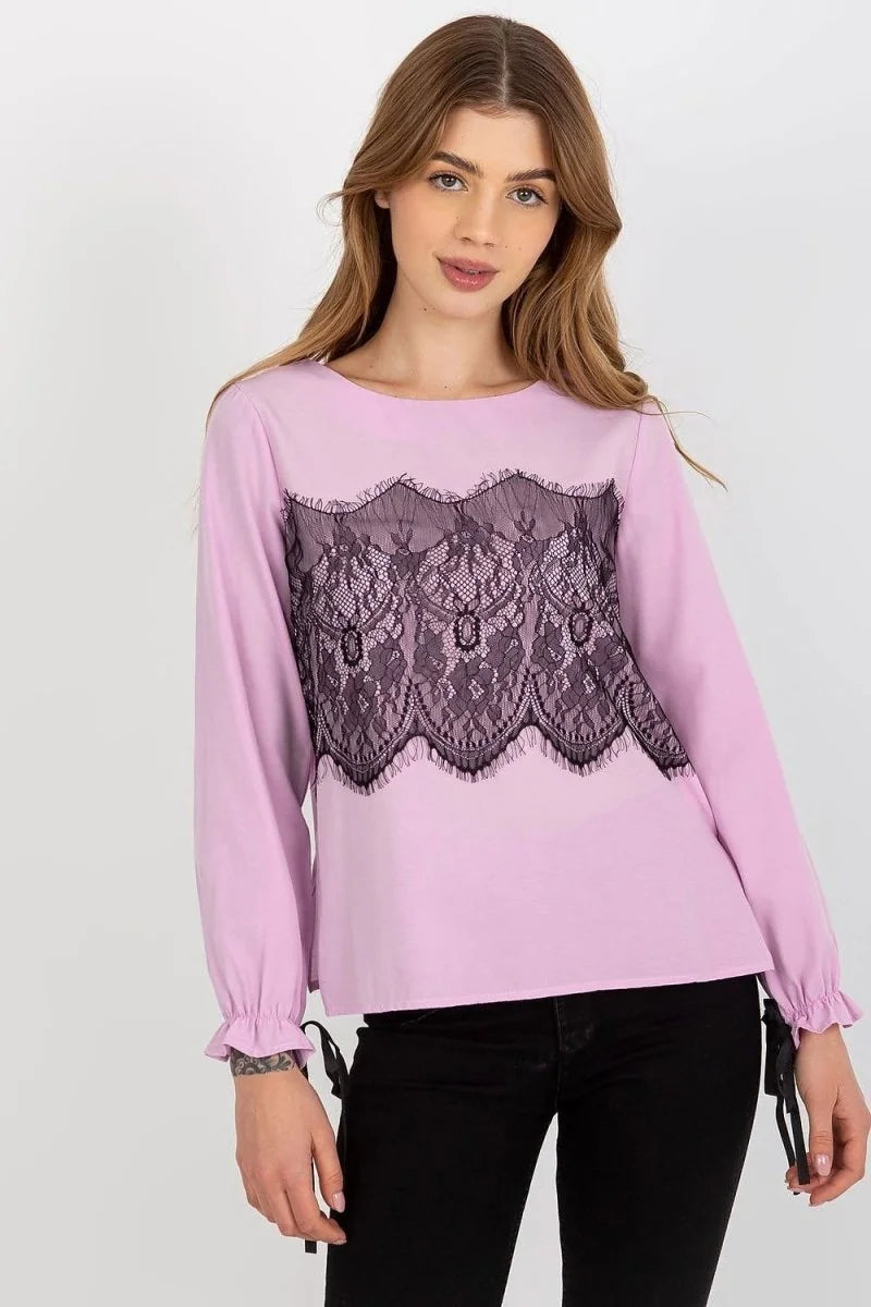 Light pink long-sleeved top with black lace trim across the chest, on a model wearing black jeans.