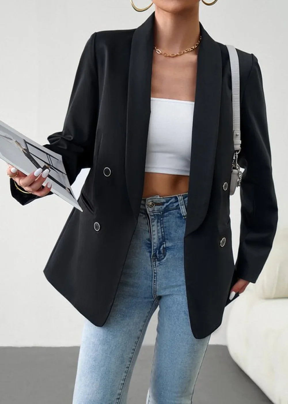 Black double-breasted blazer with gold chain necklace and light wash jeans.