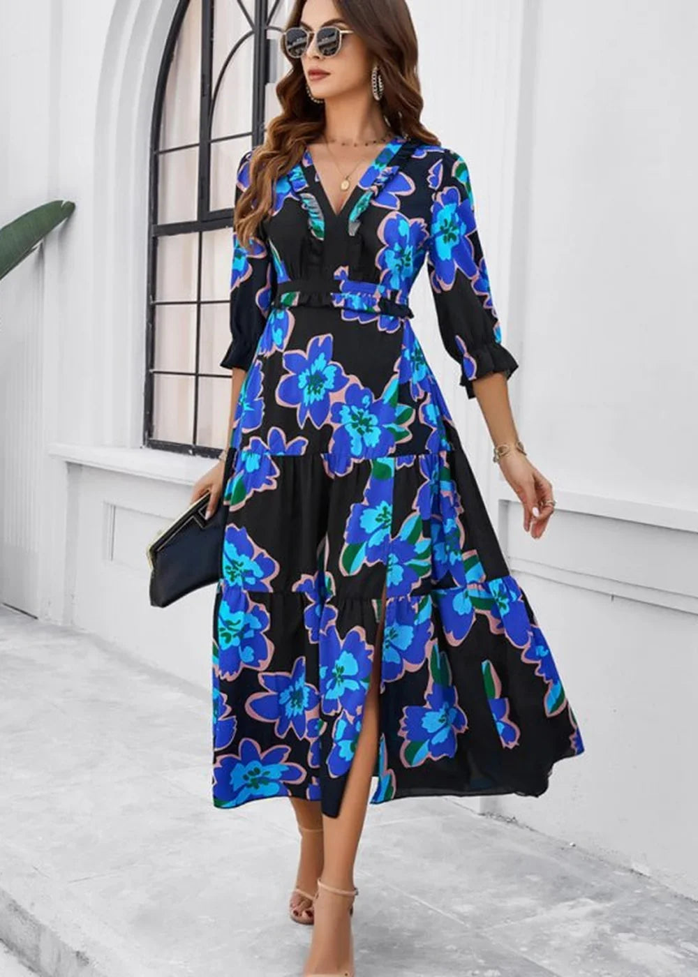 Black dress with blue floral print, v-neck, ruffled trim, and thigh-high slit.