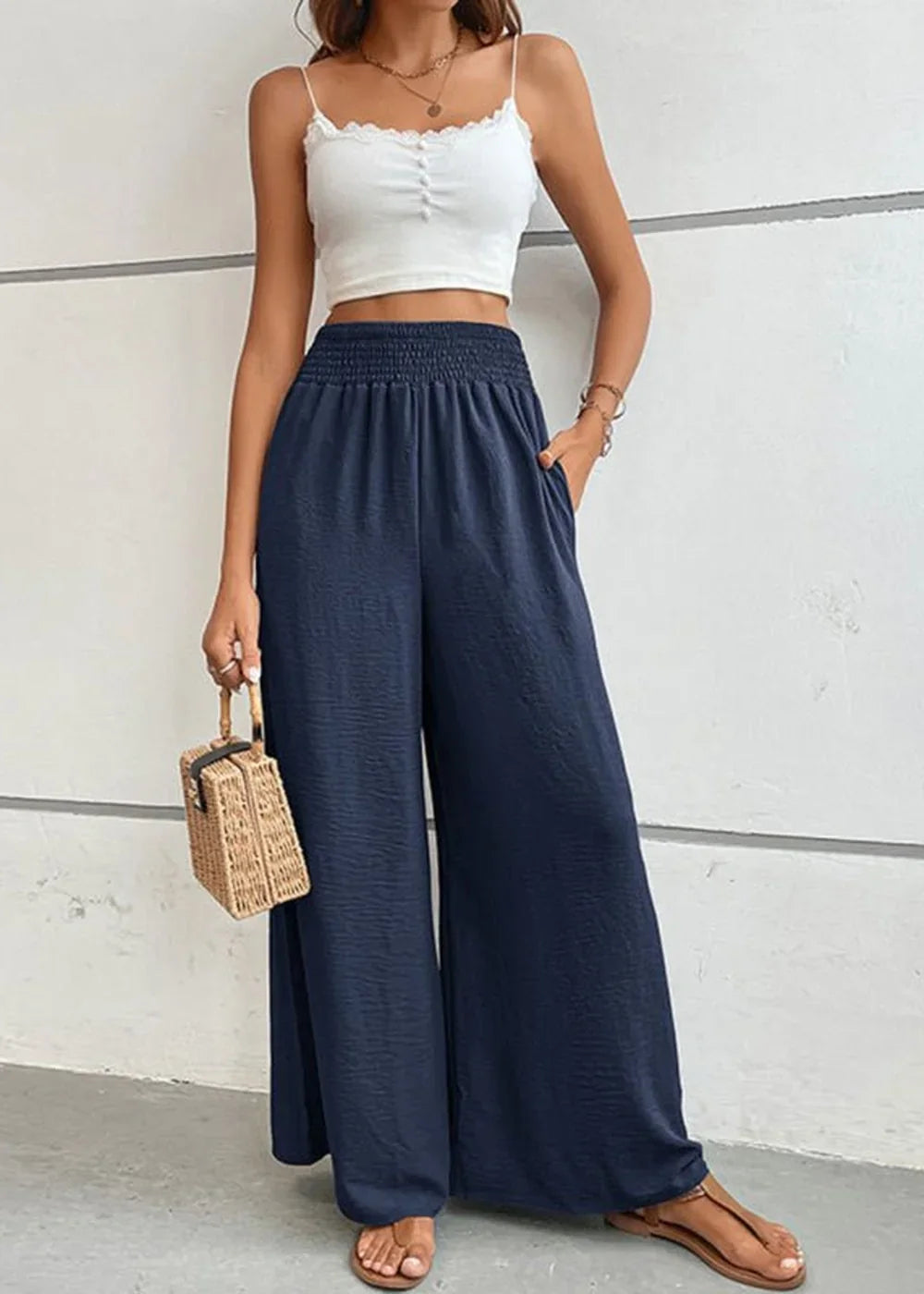 Navy blue wide-leg pants with smocked waistband and textured fabric.