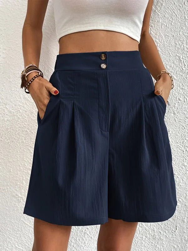 Navy blue textured shorts with a high waist and button closure, on a model.