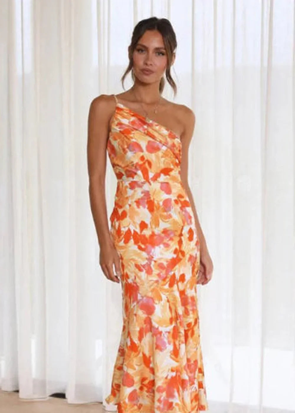 Orange and white floral print one-shoulder maxi dress with a draped bodice.