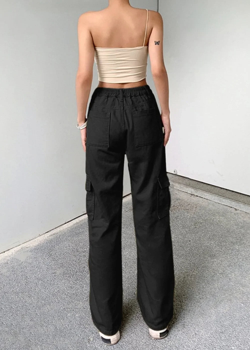 Black cargo pants with a drawstring waist and multiple pockets, shown on a model.