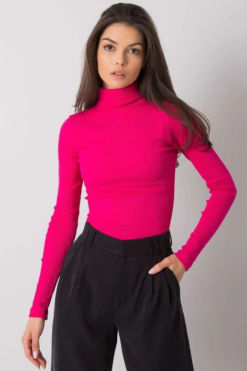 Fitted bright pink ribbed turtleneck with long sleeves, worn with black wide-leg pants.