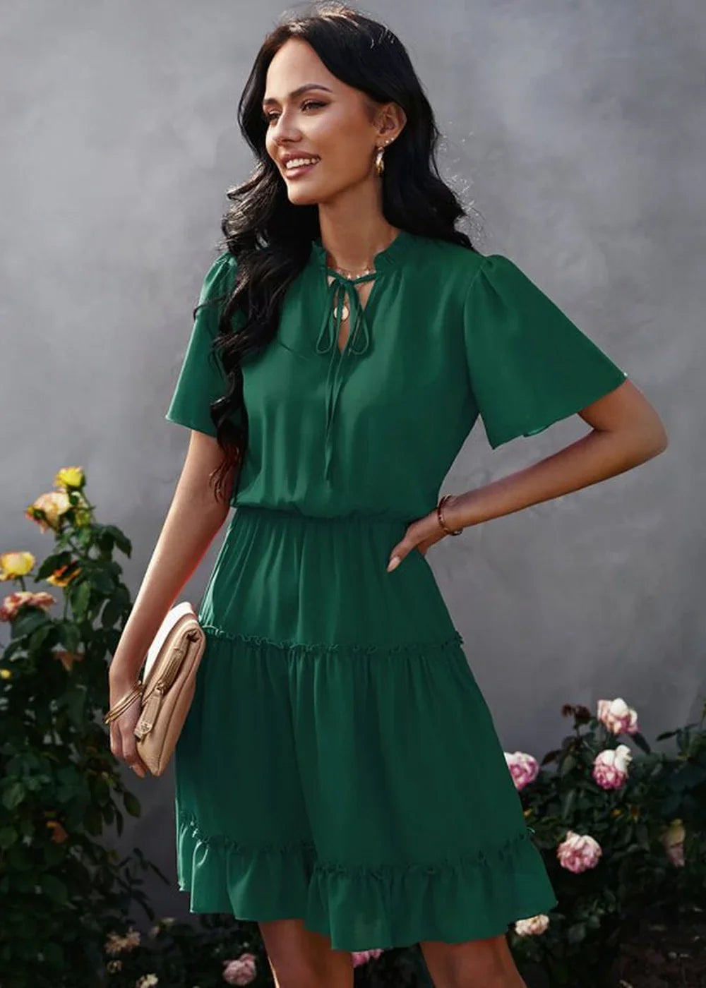 Emerald green tiered ruffle dress with tie-neck detail, worn by a model outdoors.