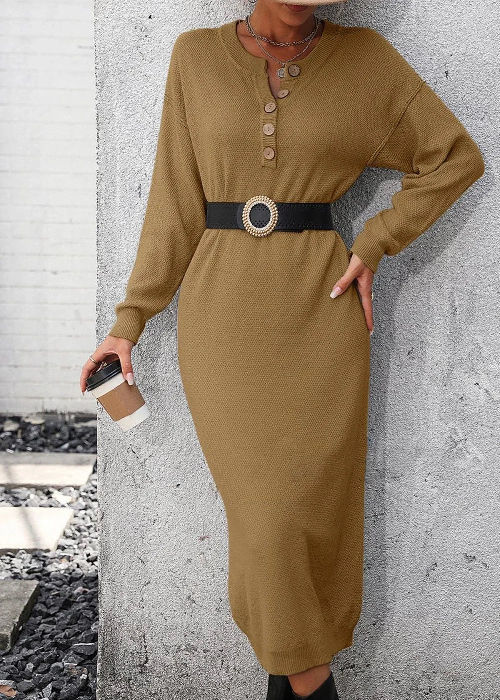 Woman in a brown knit sweater dress with a black belt and a coffee cup.