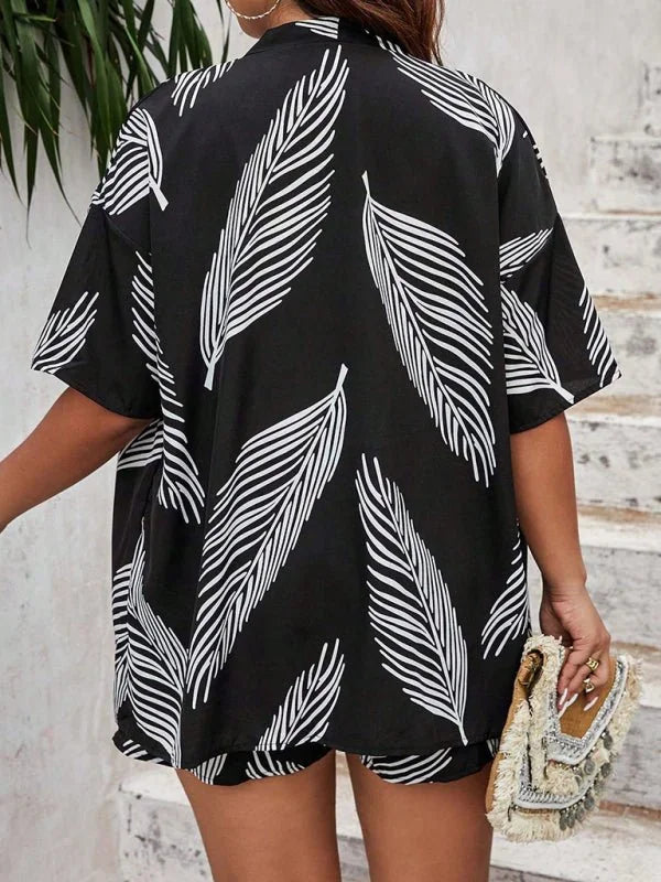 Black and white feather print short suit on model, with fringed clutch purse.