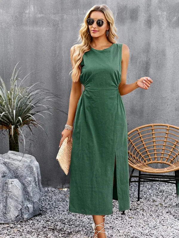 Green sleeveless midi dress with a high slit, worn by a model with sunglasses and a straw clutch.