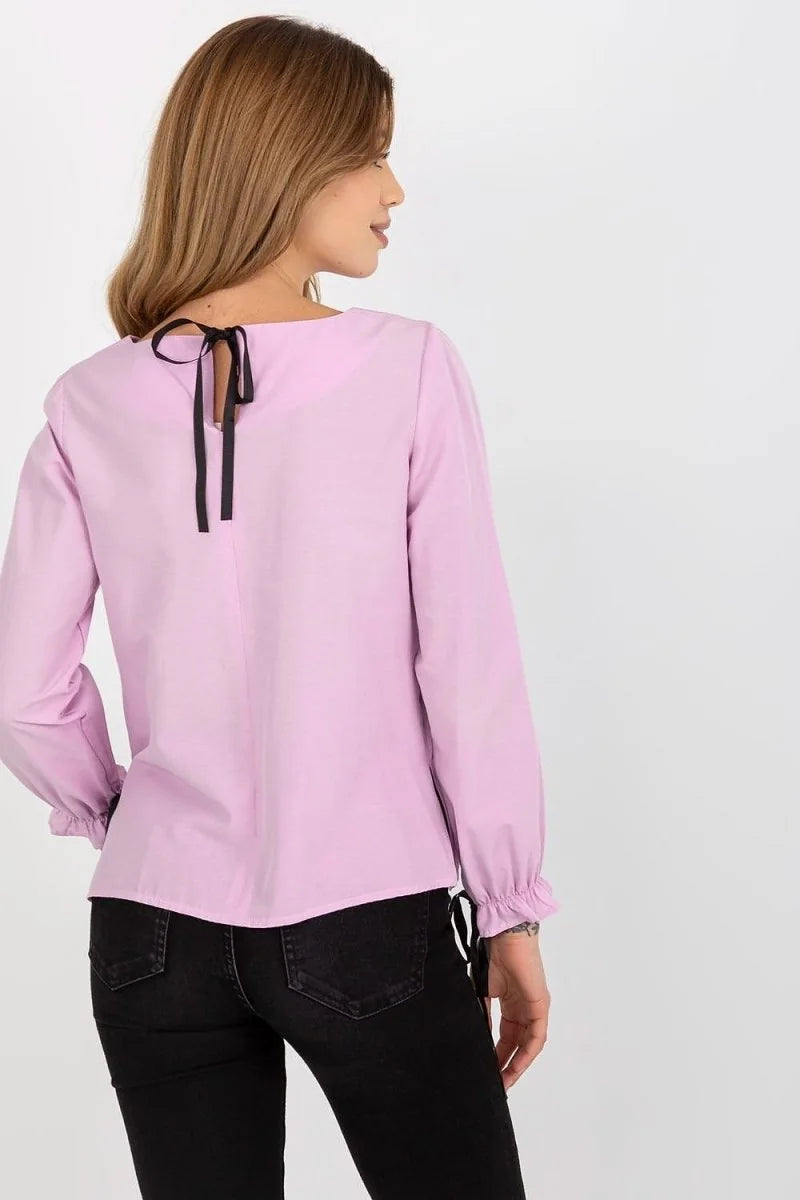 Back view of a lilac cotton blouse with a black tie at the neckline and ruffled cuffs.