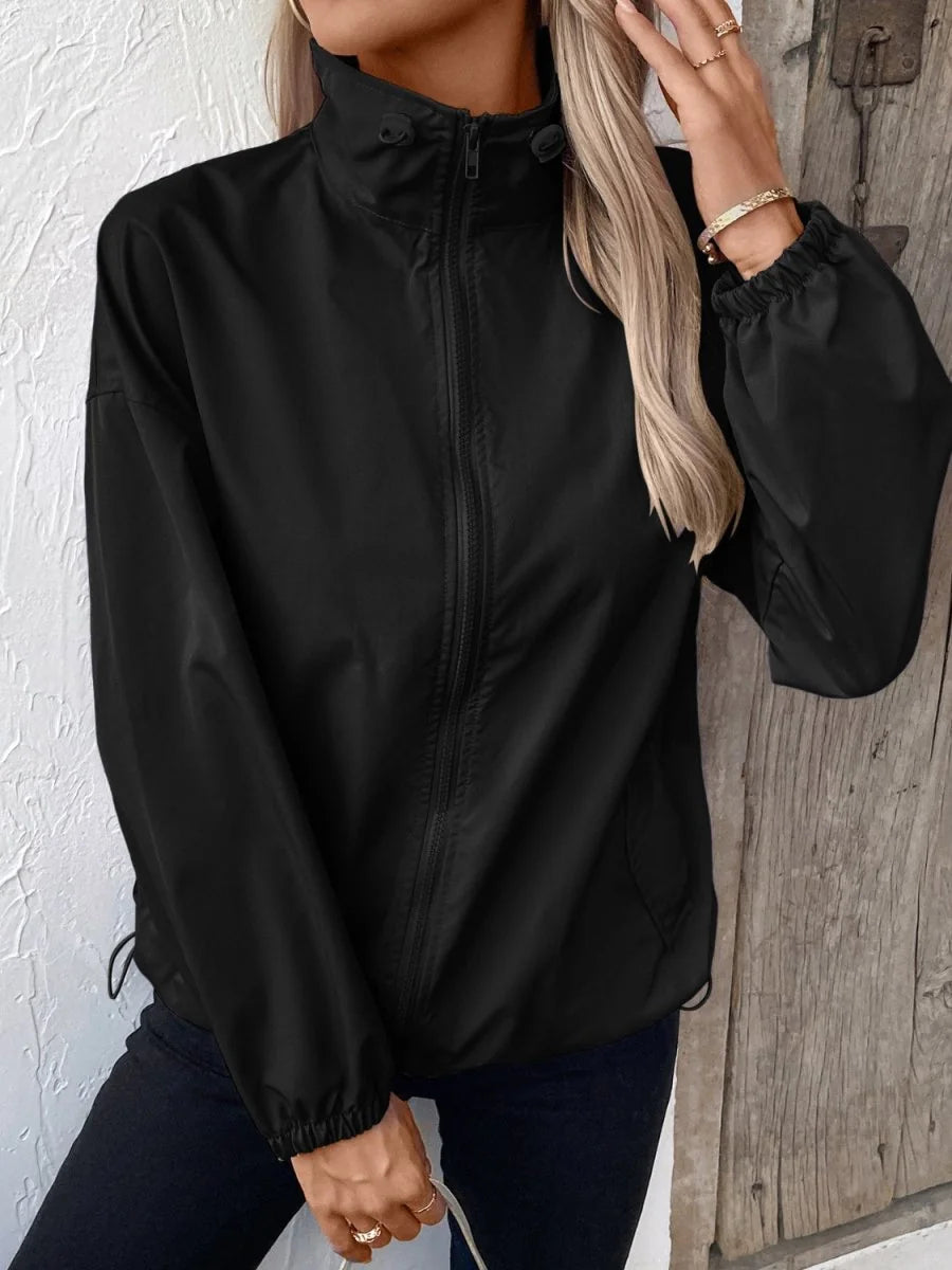 Black polyester jacket with a high collar, full zipper, and elastic cuffs, shown on a model.