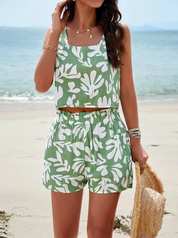 Green and white leaf print cropped tank top and high-waisted shorts set on a beach.