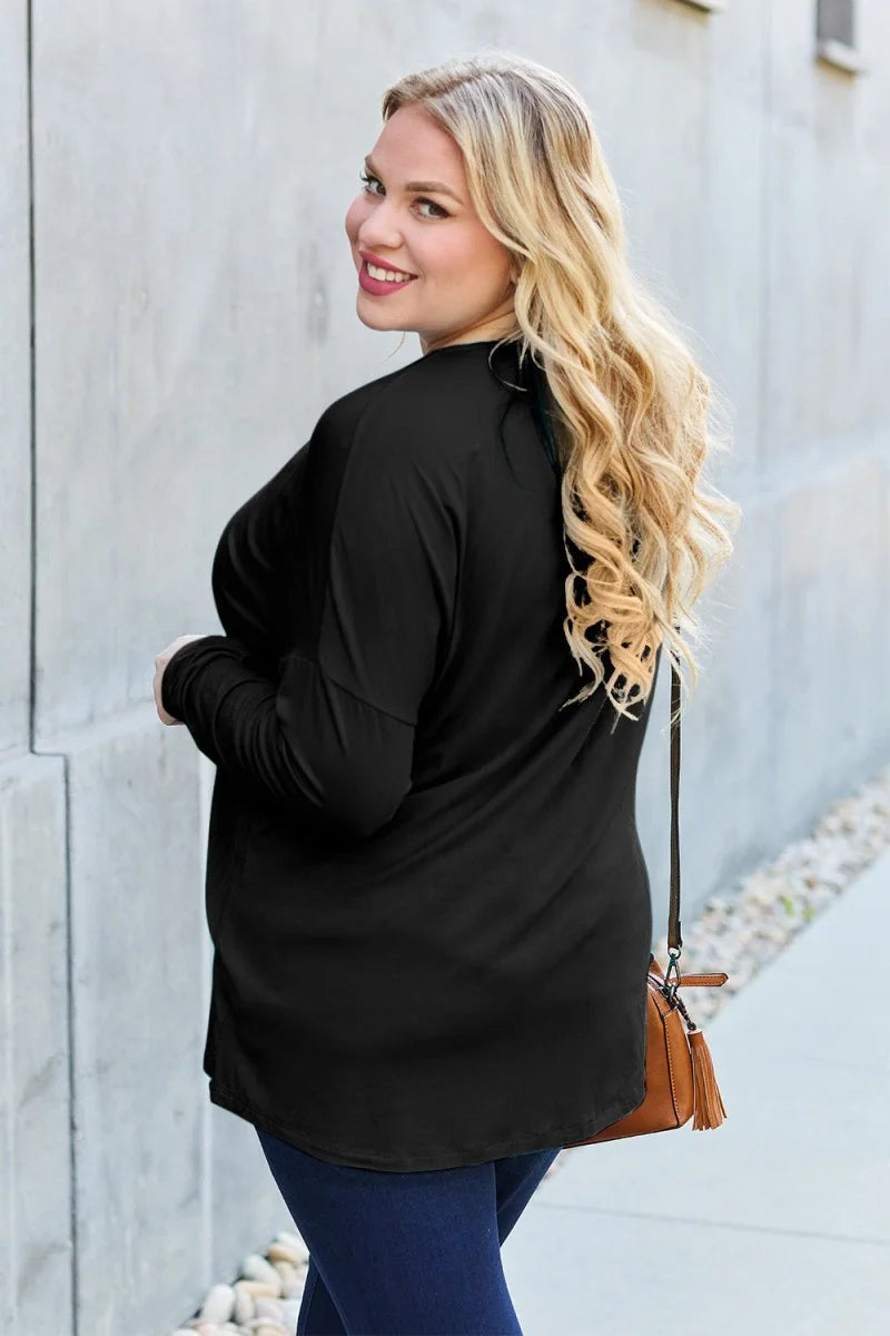 Black long-sleeve top with a relaxed fit, shown from the back with a brown crossbody bag.