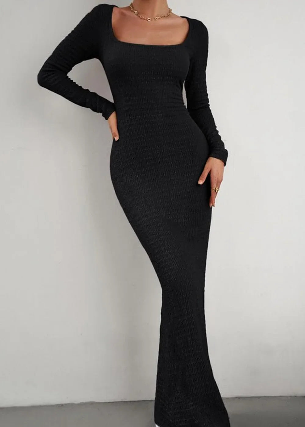 Black ribbed knit maxi dress with a square neckline and long sleeves, fitted on a model.