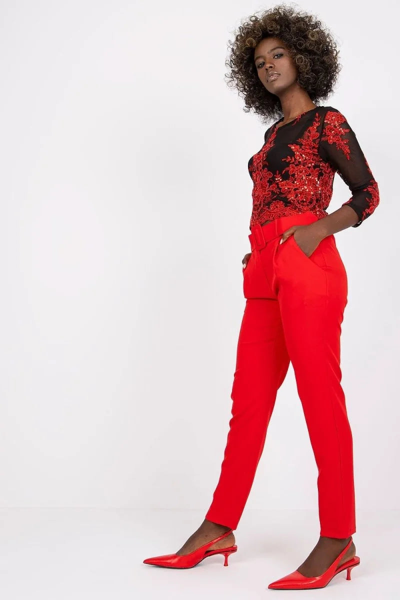 Red high-waisted pants with a belt, on a model with red slingback heels.