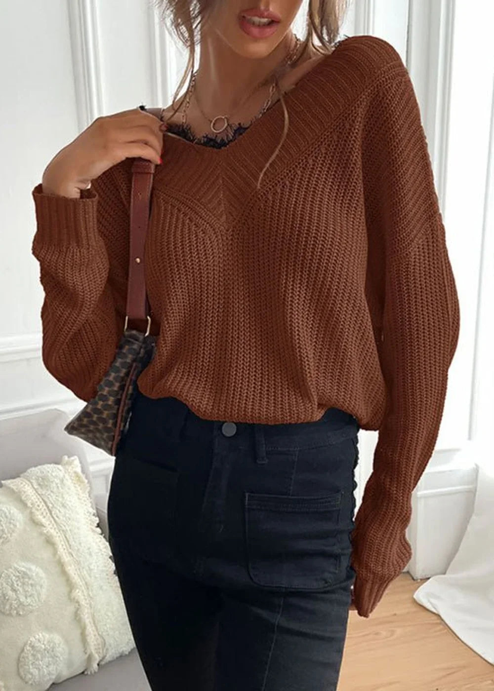 Brown knit V-neck sweater with black lace trim and black denim jeans on model
