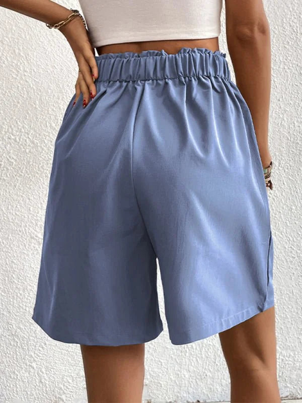 Light blue polyester shorts with a ruffled paperbag waist and a regular fit.