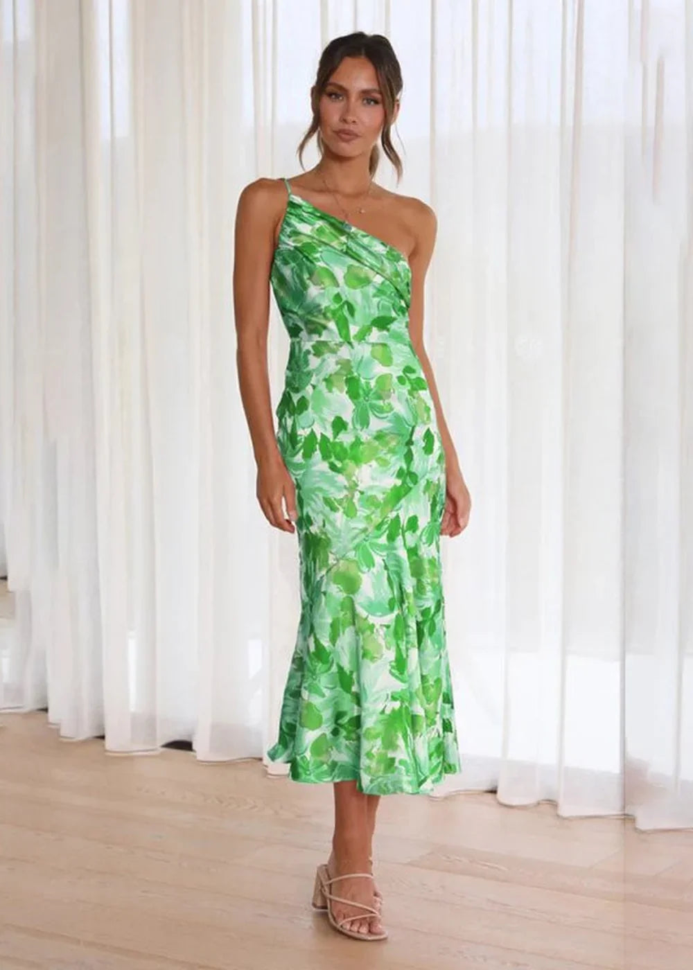 Green floral print one-shoulder midi dress with a draped bodice and ruffled hem.